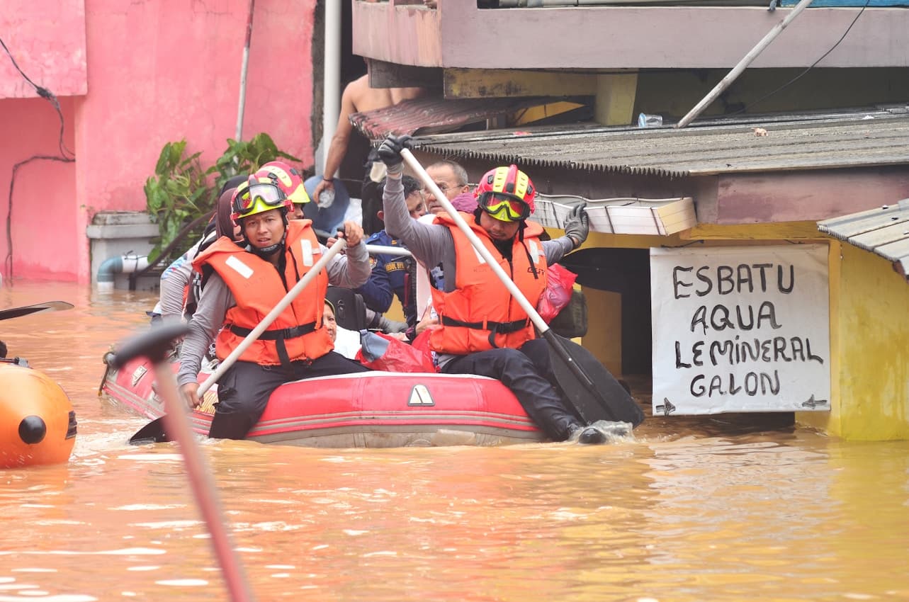 Emergency rescue workers assisting flood victims in boat